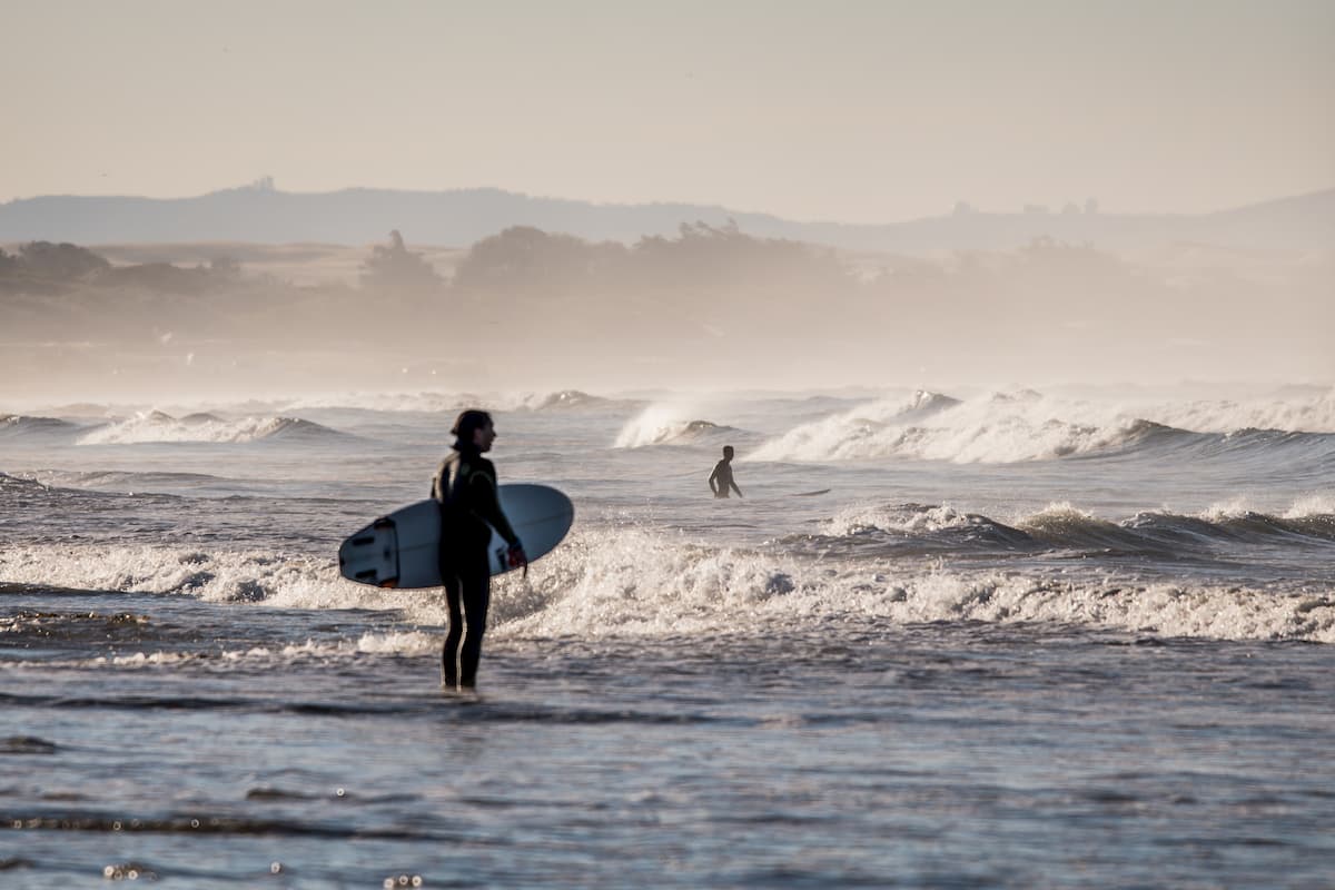 Surfeur apprentis observant les vagues avant de se mettre à l'eau